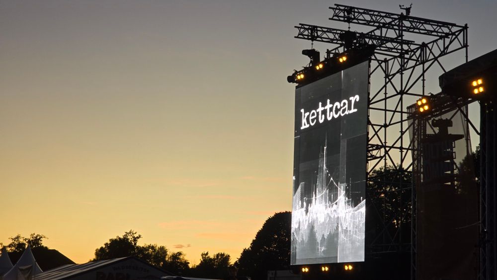 Teil einer Open Air Bühne im Abendlicht. Rechts im Bild zu sehen ist das Logo der tollsten Band der Welt.