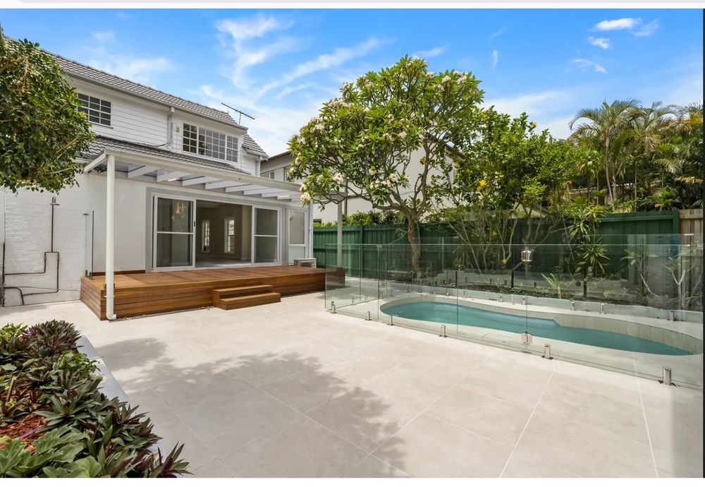 After renovation, all white paving with new pool.