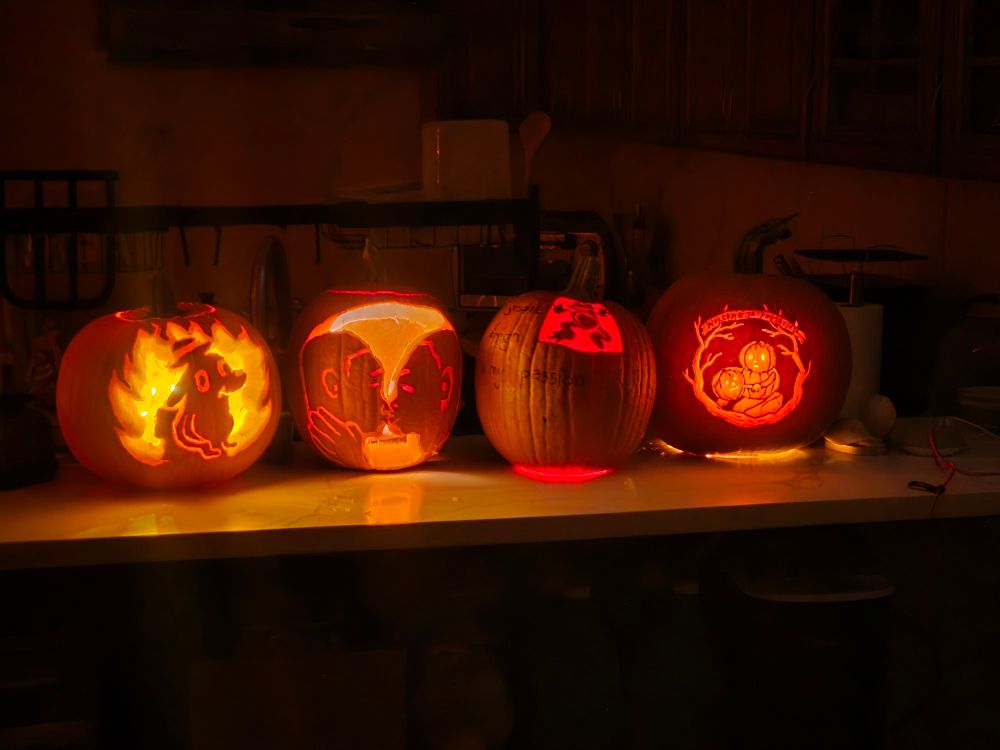 4 carved pumpkins, each with a unique design. One is a little more unique than the others...
