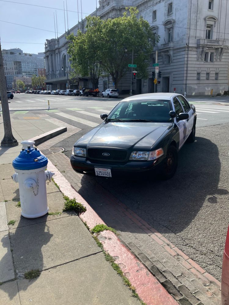 San Francisco police car parked in a red zone in front of a fire hydrant