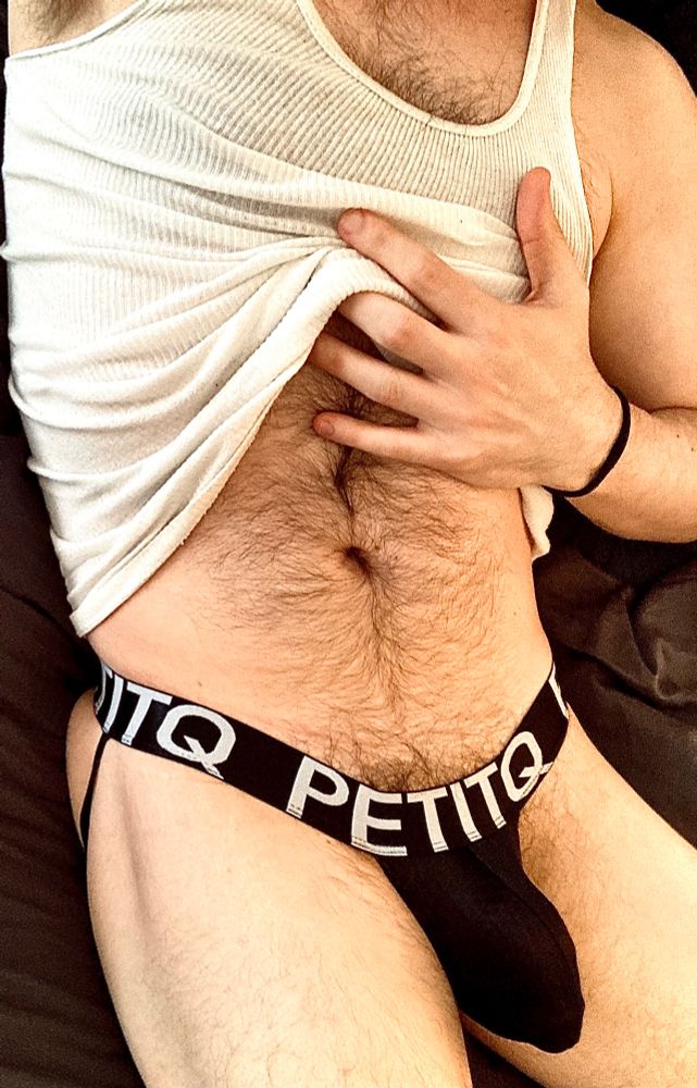 photo of me with the gray shorts pulled down and out of frame, while my hand pulls up my tank top to show off my furry tummy. the black underwear are being pulled down by my semi, revealing a good bit of my bush. 