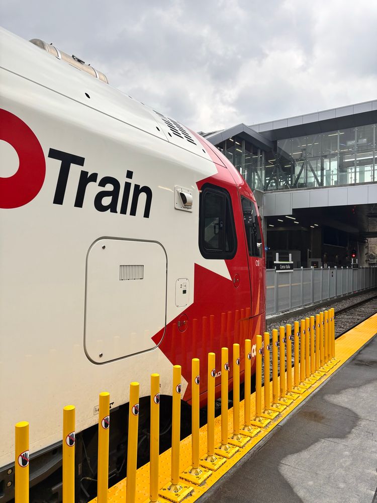 An O-Train line 2 vehicle pulled into an open-air station