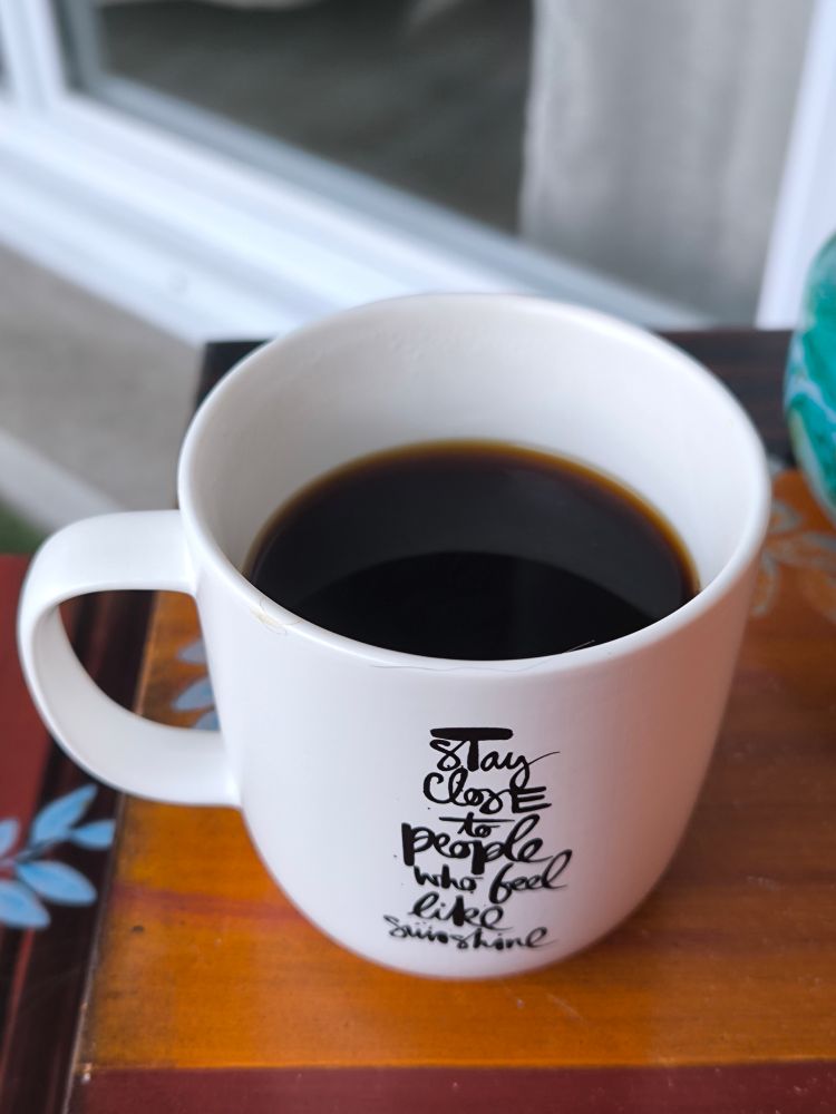 Mug de café rempli avec inscription "stay close to people who feel like sunshine".
Terrasse. 