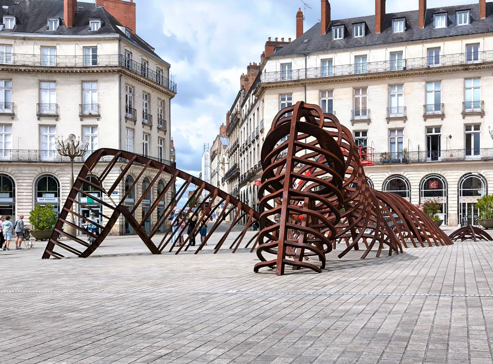 Sculpture métal, Voyage à Nantes, place Graslin. Sculpture représentant une femme allongée les jambes écartées. 