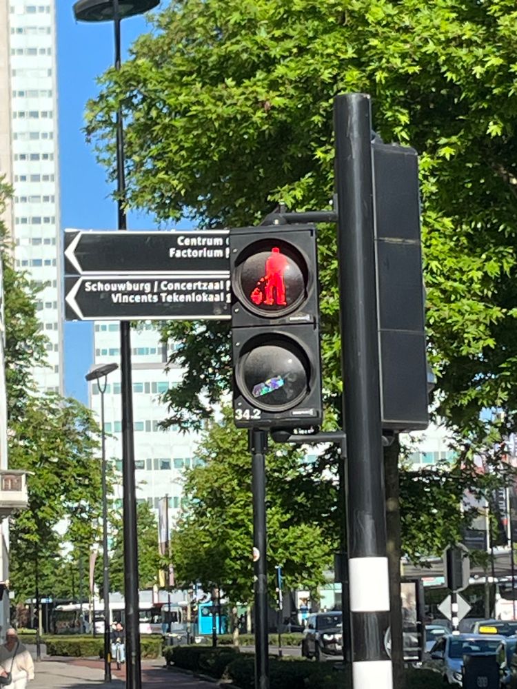 Pedestrian crossing lights in the Dutch city of Tilburg, showing an image of a man peeing into a jug