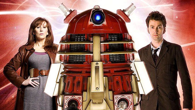 Donna and the tenth Doctor standing either side of the red Supreme Dalek