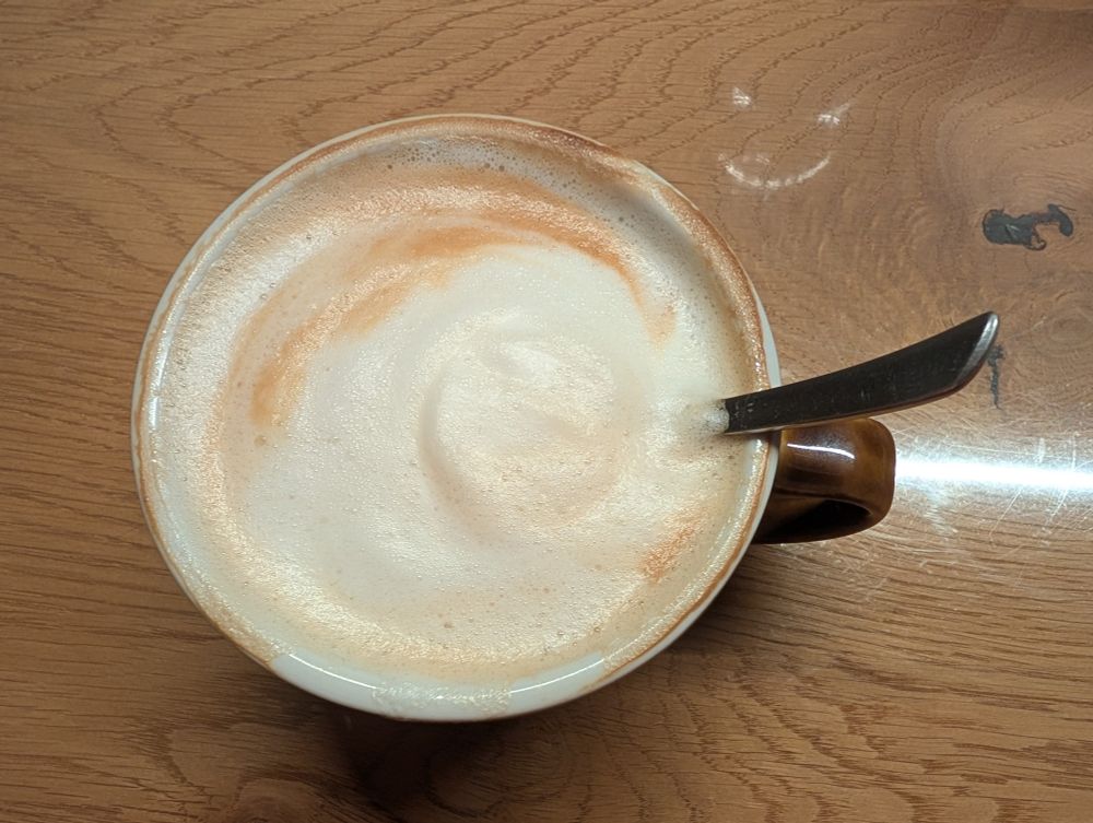 Eine Tasse Cappuccino steht auf dem Tisch