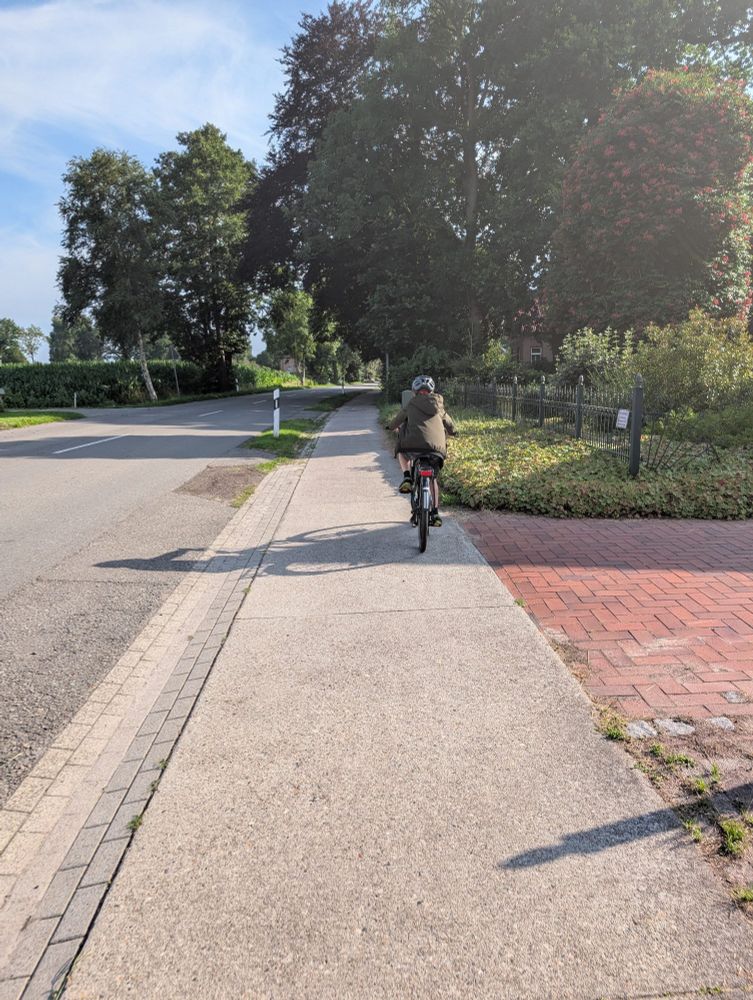 Ich fahre mit dem Fahrrad über den Fahrradweg. Vor mir fährt ein anderer auch Fahrrad