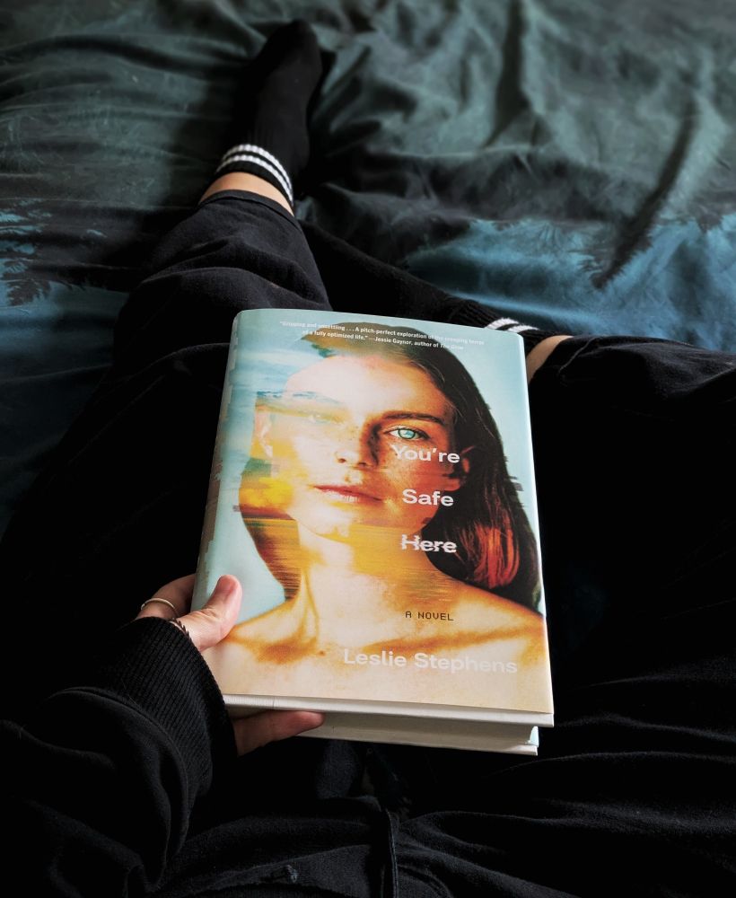 Andrea holding a copy of You're Safe Here by Leslie Stephens 