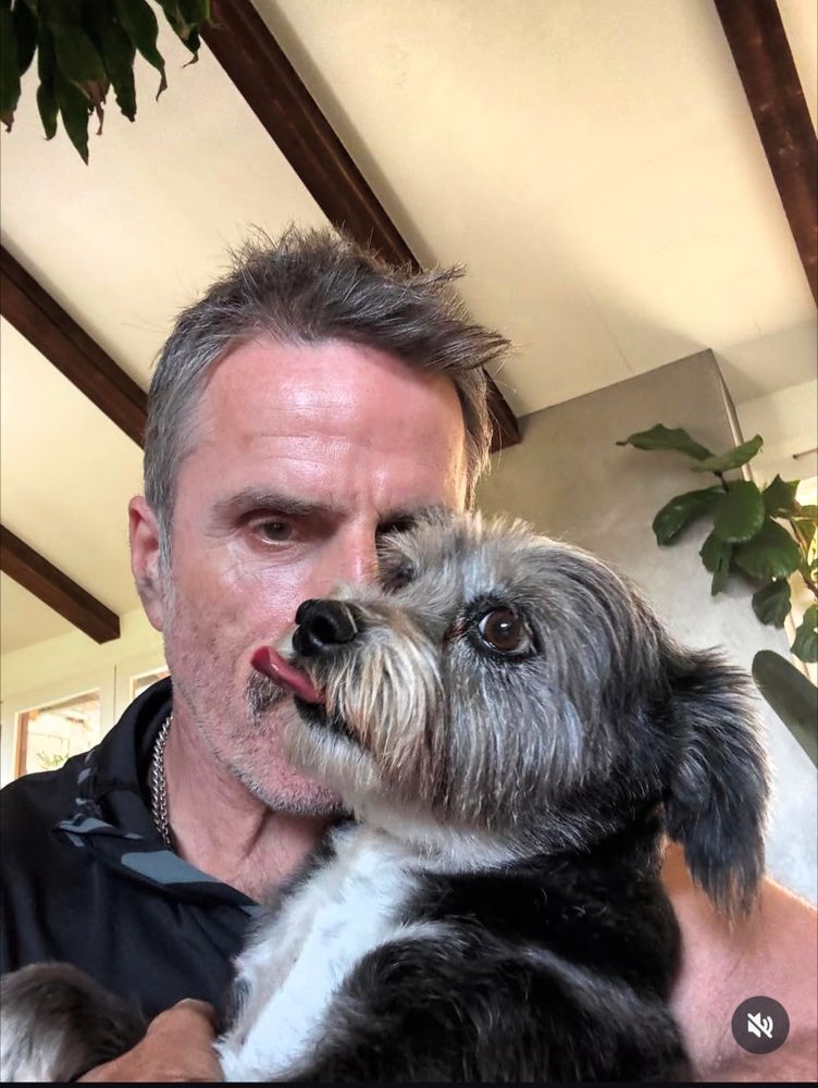 Color photo of Con O'Neill holding a small dog.