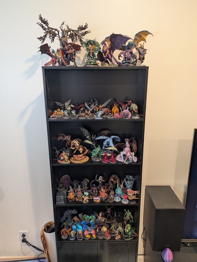 A bookshelf of mostly custom painted minis. 
