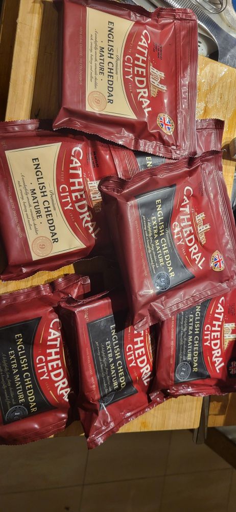 Photo of nine or so packages of Cathedral City cheddar cheese, both "mature" (9 month old) and "extra mature" (12 month old). It claims to be "the UK's No. 1 cheddar". It also happens to be Italy's No. 1 cheddar by default. Honestly I've had better but it ain't bad and beggars can't be choosers.