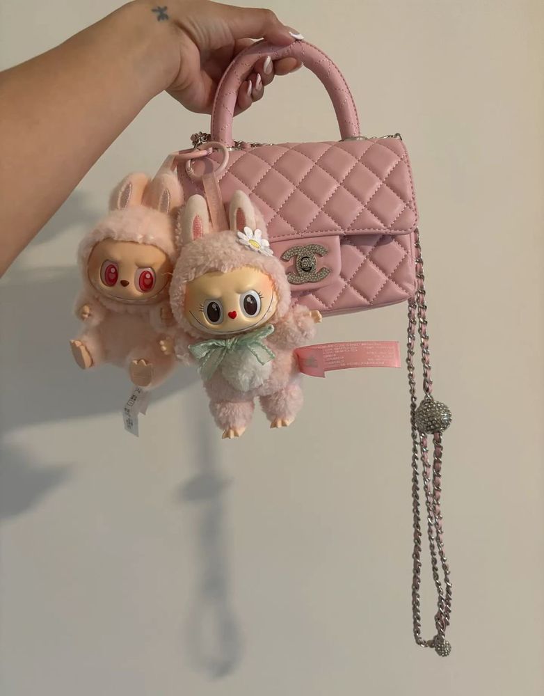 Des Labubus roses accrochés à un sac Chanel, rose lui aussi.