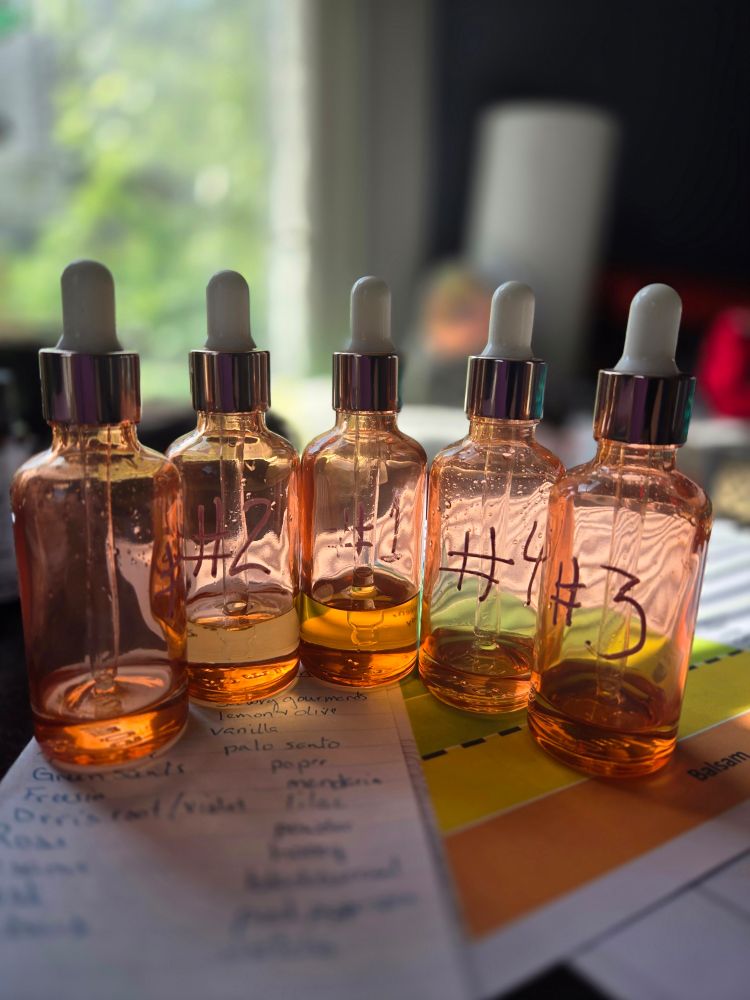 5 dropper bottles with varying amounts of liquid,  all labeled from 1 to 5, posed on top of some papers.