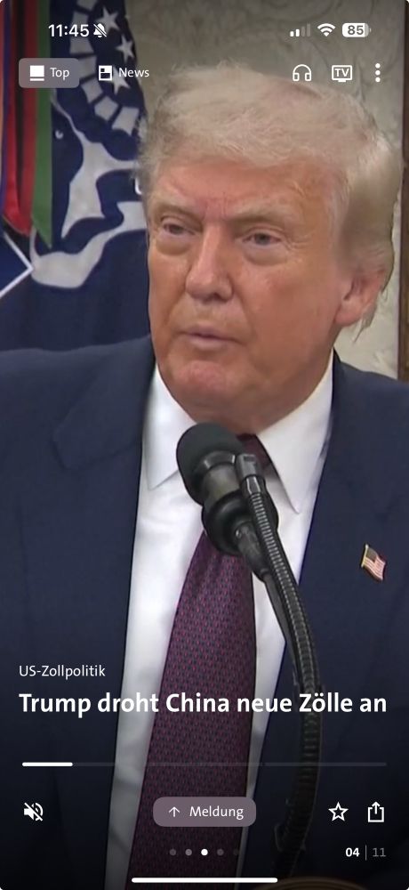 Screenshot von Donald Trump. Darauf sieht man ihn während er irgendwas in ein Mikrofon sagt. Seine Augen machen einen geschwollen und rötlichen Eindruck. Unten die Textteile: Trump droht China neue Zölle an.