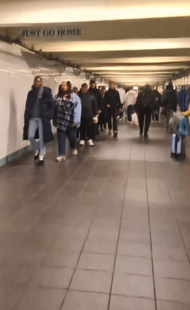 overlit subway with JUST GO HOME plate across beam