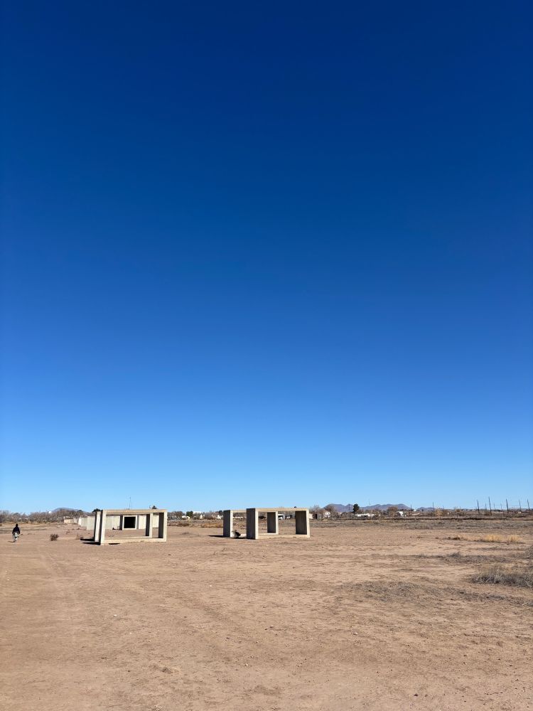 Long shot with Donald Judd concrete box in the distance, bright blue sky.