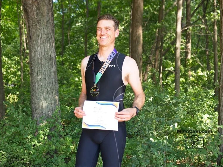 Me with a finisher's medal, a certificate from the race, and a smile despite being wiped out and sore.