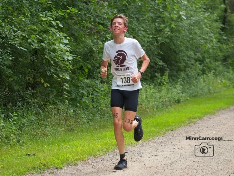 My son running along a gravel road with a smile on his face