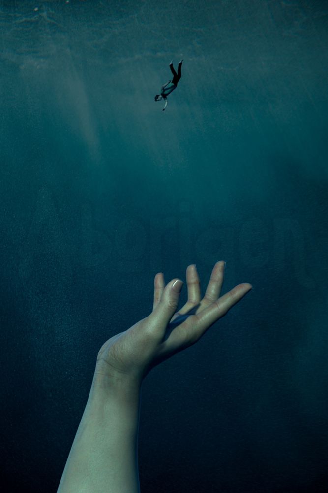 A tiny man sinks into deep blue waters; a gigantic arm and hand reach up from the depths, ready to catch him.