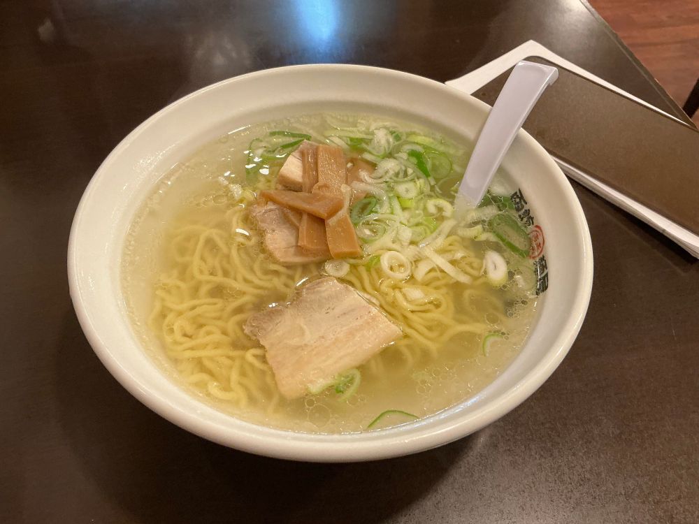Bowl of ramen with clear yellow broth.