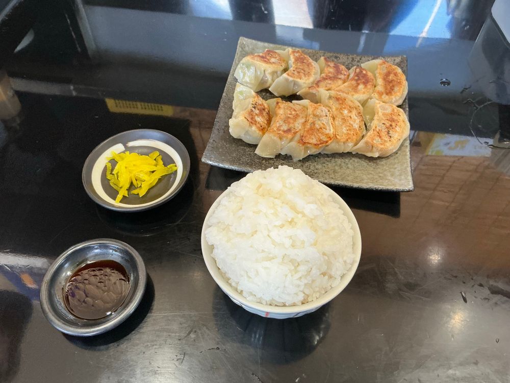 Plate of 10 gyoza, plus large bowl of rice and a few pickles.