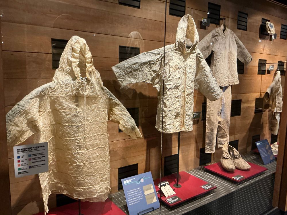 Some sets of hooded garments in white, with a thin crinkly-paper look to them.