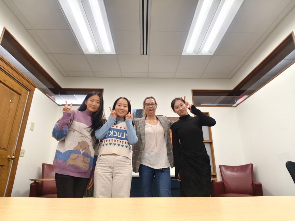 4 women posing for a photo. 3 are giving peace signs and the one crazy white lady is sticking her tongue out and giving rabbit ears to the women on either side of her