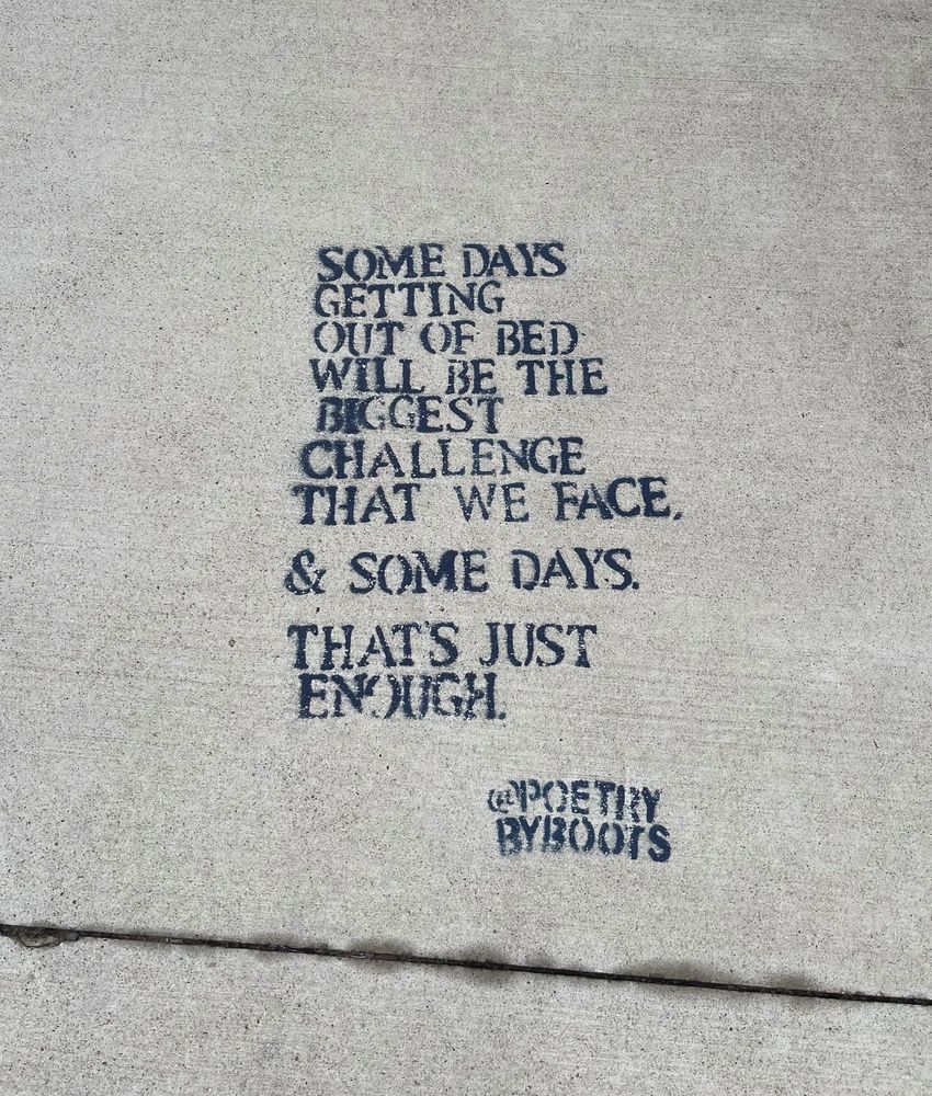 A poem spray-painted on the sidewalk that says “Some days getting out of bed will be the biggest challenge that we face. & some days that’s just enough.” And it’s tagged @poetry by boots 