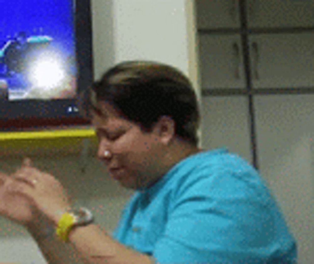 a woman in a blue scrub is sitting in front of a tv