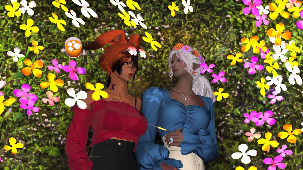 Ranni in a mesh red off the shoulders blouse and her red x glasses lays in a field of yellow, purple, and white flowers with a whiskey near her head next to her wife Keres with orange and purple flowers in her hair and a light blue blouse with a floral pattern and a long cigarette in her hand.