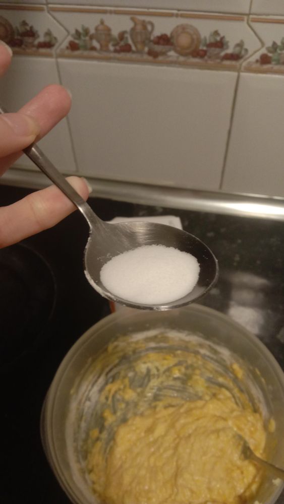 a funky round tablespoon of black metal containing an undetermined quantity of sodium bicarbonate powder
