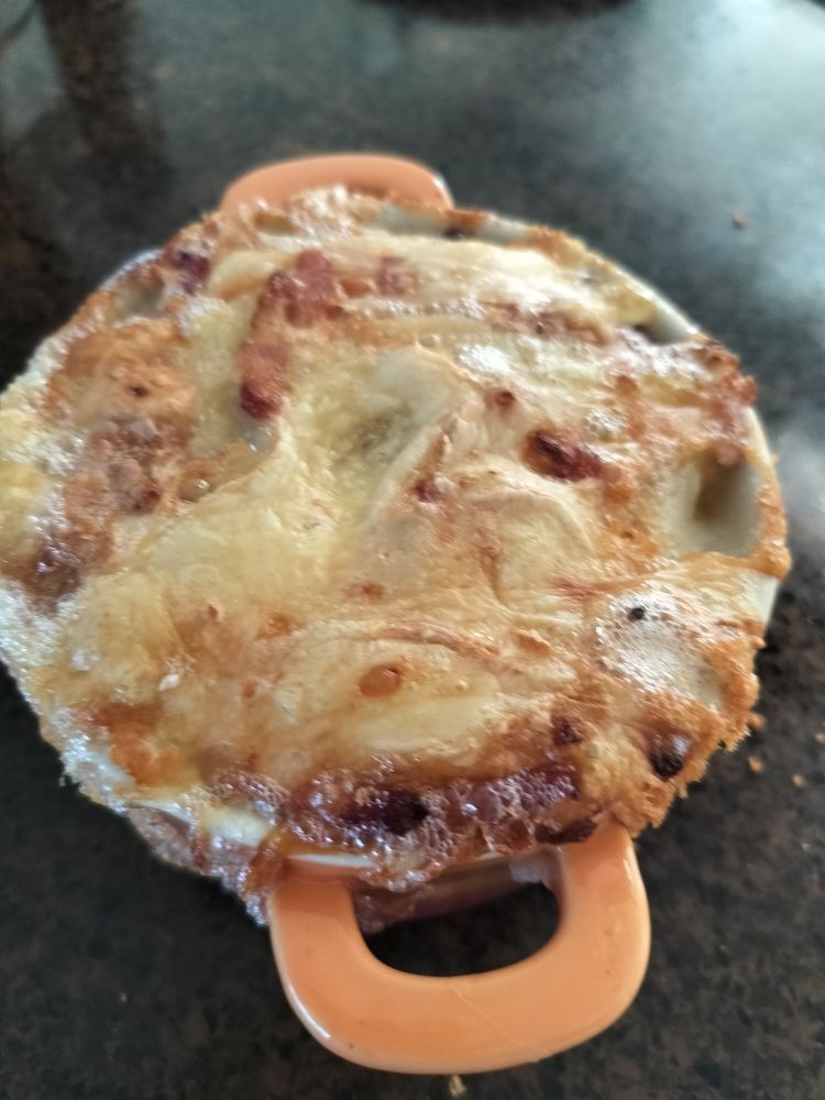 Ovenschaal met Tartiflette. Mengsel van uien, spek, aardappelen en Reblochon