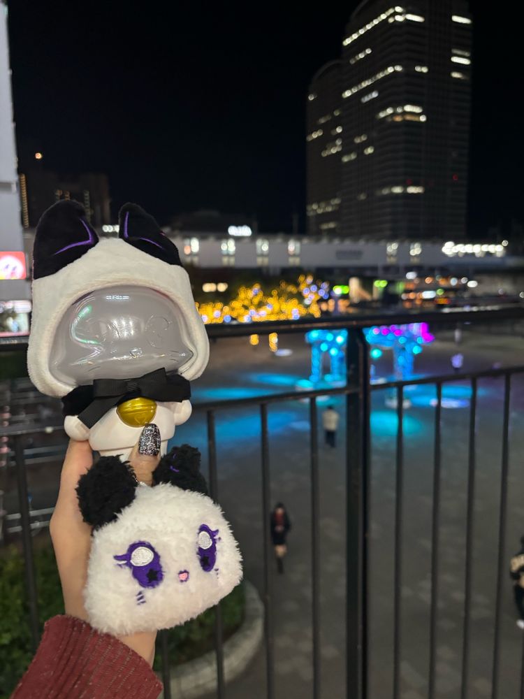 海浜幕張駅をバックに、ミーアイオリジナルペンライトと、ミーアイのメンバー別キャラクターキーホルダーを掲げています。キーホルダーは耳が黒い猫を模しておりふわふわで愛らしいです。