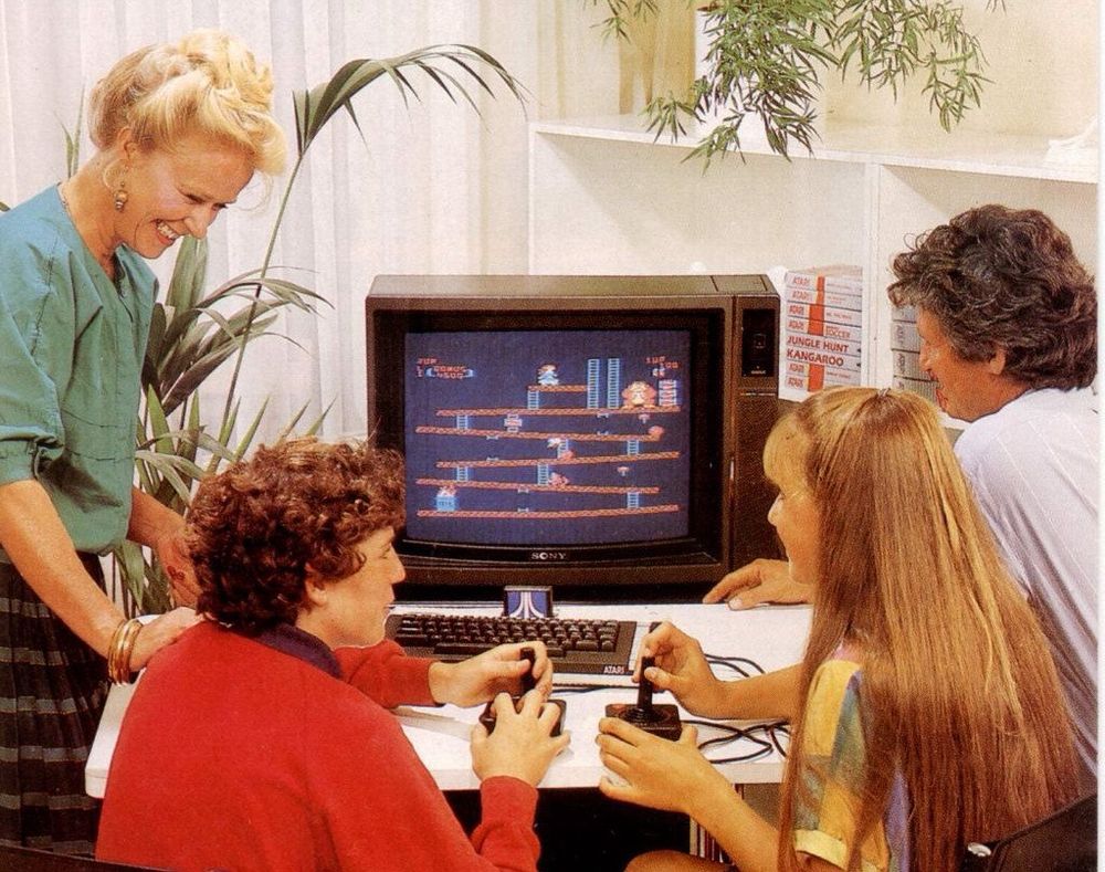 Vintage marketing photo of family playing Atari 800 XL