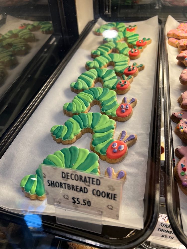 Cookies in a display cabinet shaped like the protagonist in The Very Hungry Caterpillar (1969).