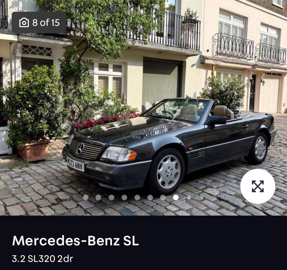Screenshot of an advert for a Mercedes 320SL. The picture shows it parked on a cobbled street.