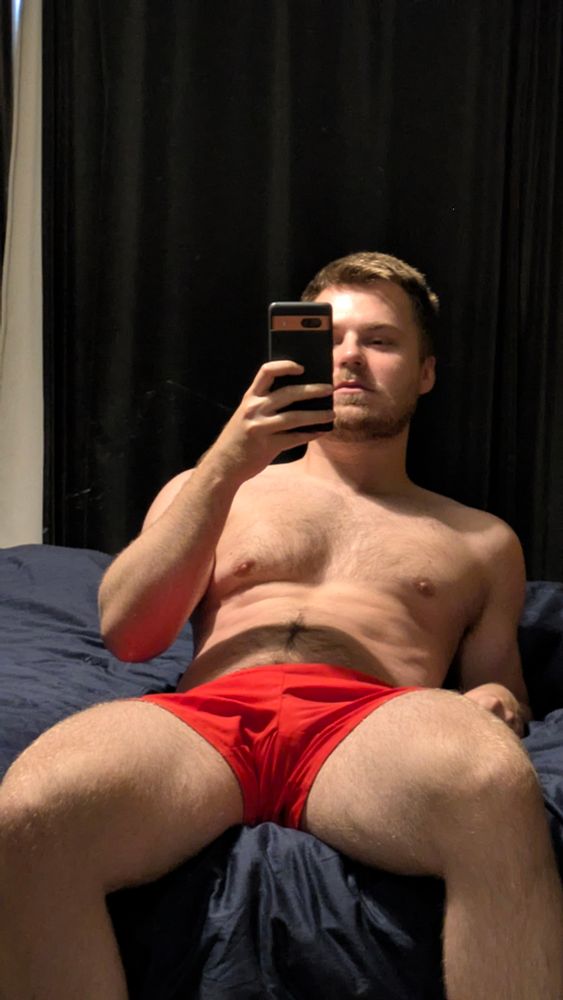 Me in red shorts on a bed