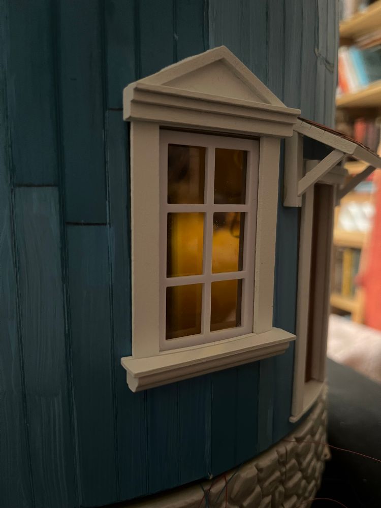 Peeking though the window to see a big whale oil lamp reflected on the walls. 