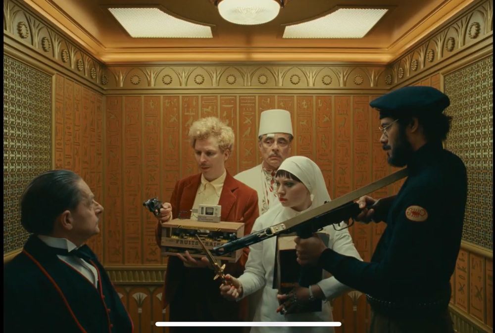 The elevator scene in THE PHOENICIAN SCHEME, where Korda, Bjorn, Liesl, and the freedom fighter pull their weapons on the elevator operator.