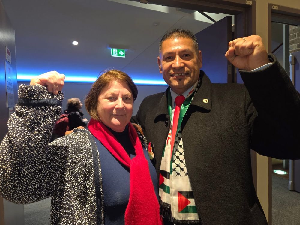 A woman and a man smiling with fists raised