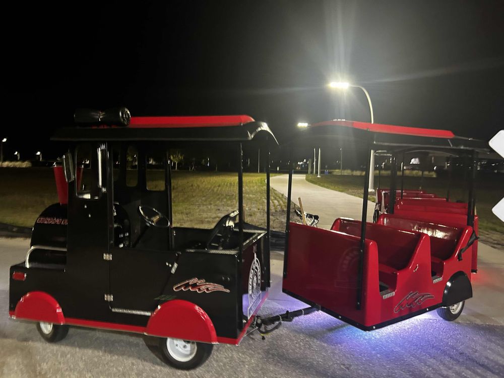 The same tram cosplaying as a train from an earlier post, but with purple and red lights underneath it.