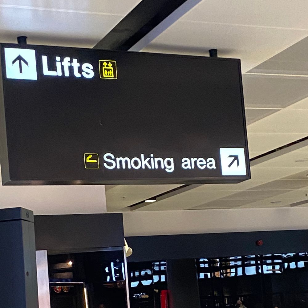 Sign in an airport directing you to the “smoking area”