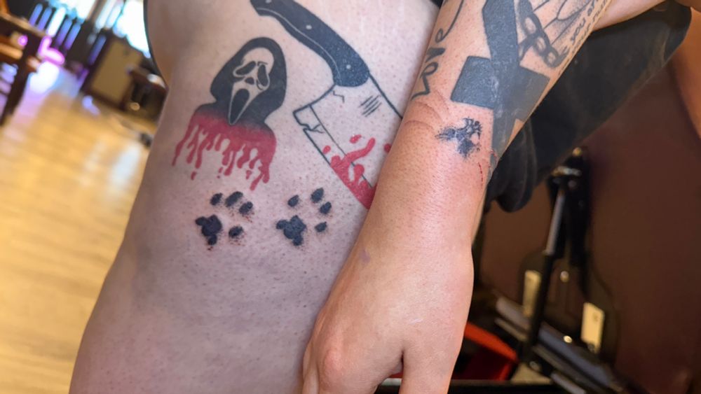 Cat paw and nose prints tattooed on thigh and wrist