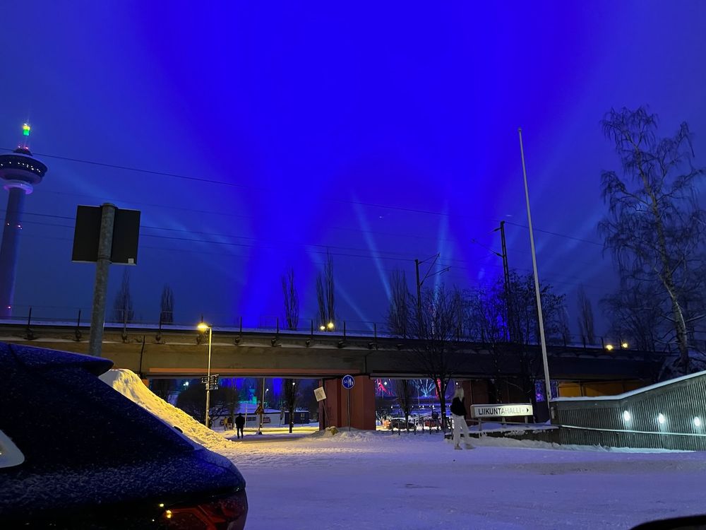 Särkänniemen valoshow. Siniset ja valkoiset valonheittimet pyyhkivät pilviä.