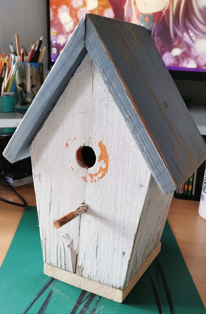 Photo d'une maison d'oiseau blanche abîmée 