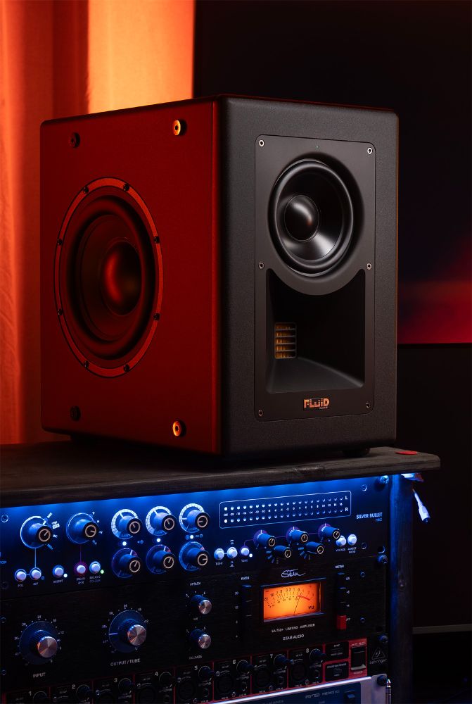 Fluid Audio Image 2 studio monitor placed on a rack with professional audio equipment, illuminated by warm orange and cool blue lighting. The monitor features a sleek black design with a visible woofer, AMT tweeter, and high-end build quality, making it ideal for precise studio monitoring.