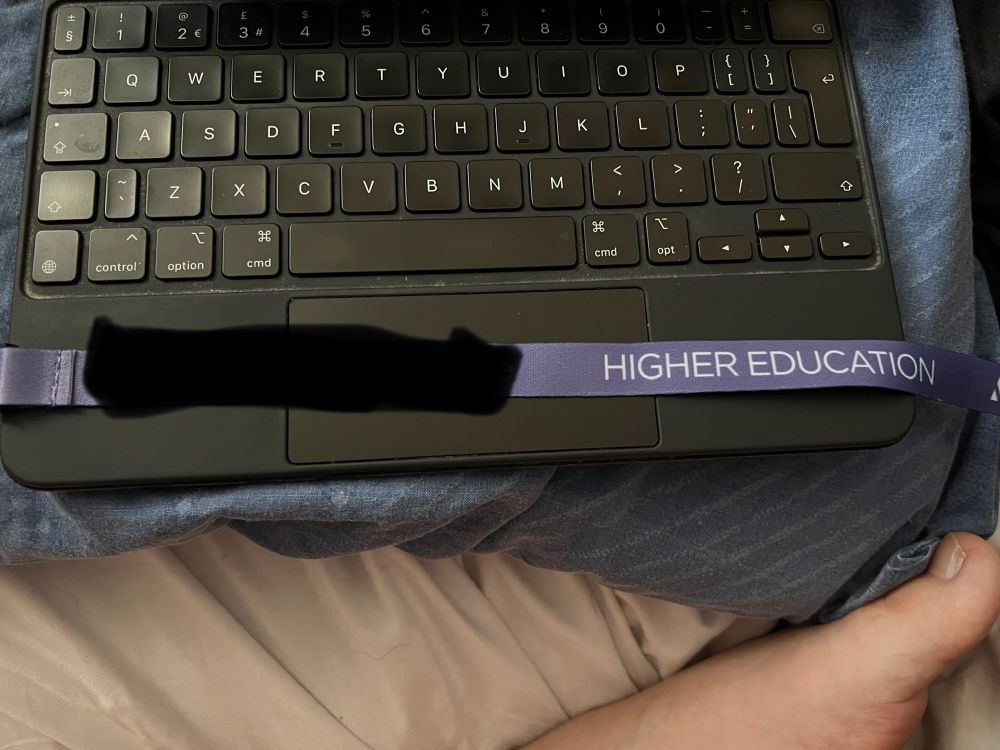 Purple lanyard with text reading “HIGHER EDUCATION” and the name of the college censored.