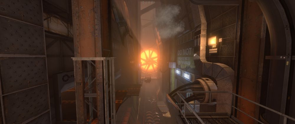 A scene of a large underground industrial area in Aperture Science. A catwalk occupies the left side of the room, while a diversity vent, warning sign, and catwalk take up the right side. At the very back of the room is a large turbine with an orange glow coming from behind it.