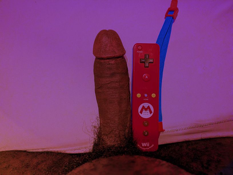 a picture looking down at my erect penis which is next to a wii remote. they're basically the same size, but my dick is about half an inch longer :)